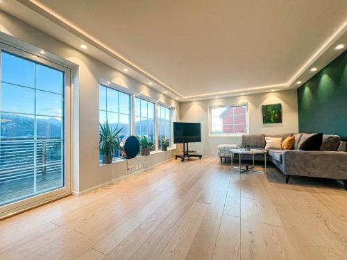 a living room with a couch and a large window at Penthouse apartment with amazing view. in Tromsø