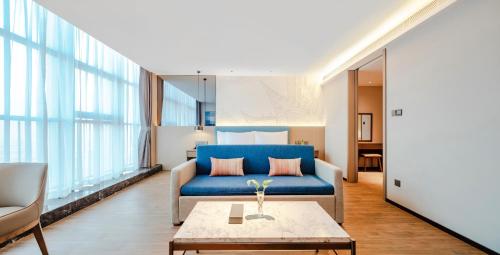 a living room with a blue couch and a table at Shanxi Xiaohe Xincheng Talent Apartment in Taiyuan