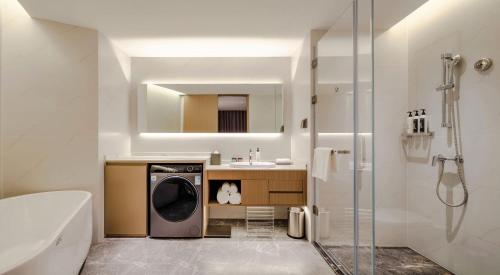 a bathroom with a washing machine and a sink at Shanxi Xiaohe Xincheng Talent Apartment in Taiyuan