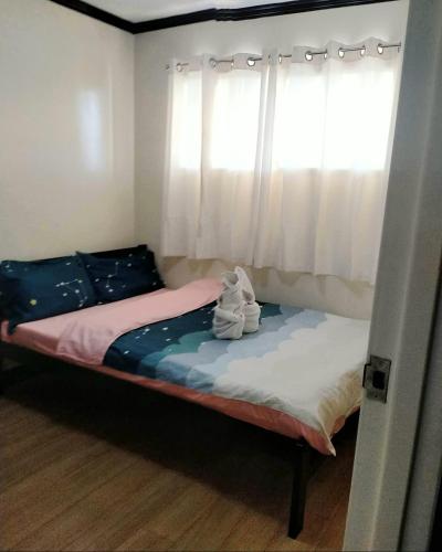 a small bedroom with a bed with a window at Ri's One Oasis w Free Pool back of SM City Mall in Davao City