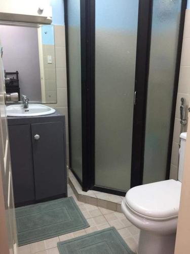 a bathroom with a toilet and a sink at Ri's One Oasis w Free Pool back of SM City Mall in Davao City