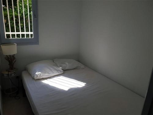 un lit dans une chambre avec une fenêtre dans l'établissement T2 climatisé 4 pers avec loggia à 300m de la plage, Argelès-sur-Mer - FR-1-388-107, à Argelès-sur-Mer