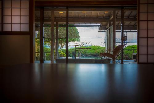 a room with a table and a chair and a window at Hotel Kitanoya in Miyazu