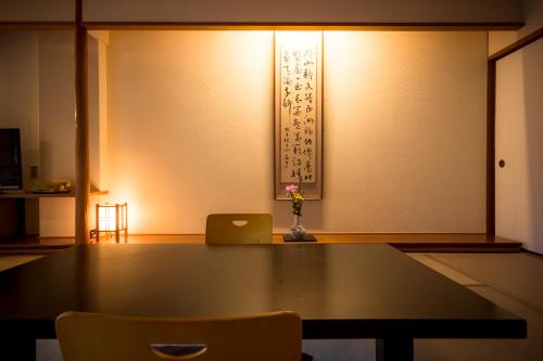 a table and chairs in a room with a wall at Hotel Kitanoya in Miyazu