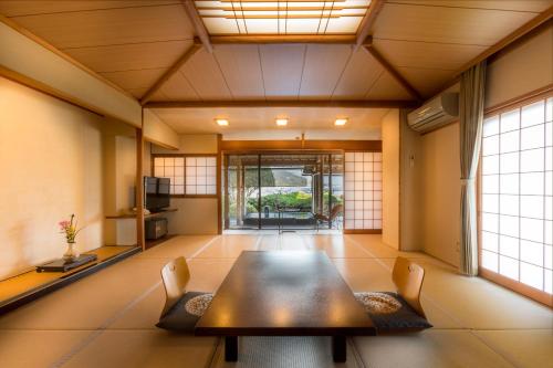 a room with a table and chairs in a room at Hotel Kitanoya in Miyazu