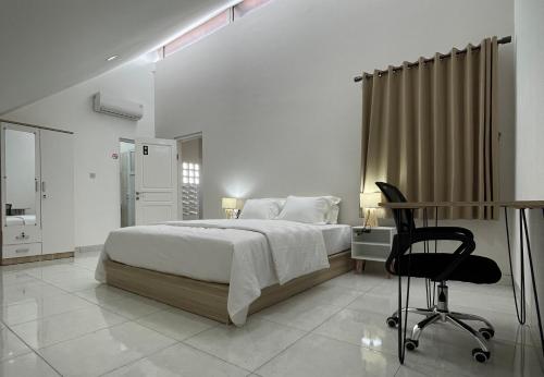 um quarto com uma cama, uma secretária e uma cadeira em 9 Residence Guesthouse Syariah Cilandak em Jakarta