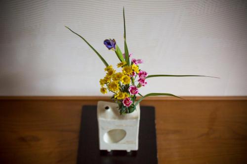a vase filled with flowers on top of a table at Hotel Kitanoya in Miyazu