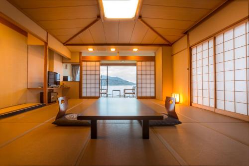 uma sala de estar com uma mesa num quarto em Hotel Kitanoya em Miyazu
