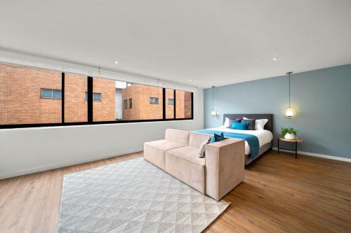 1 dormitorio con 1 cama y 1 sofá en FH - Splendid coliving in Virrey park - Bogota, en Bogotá