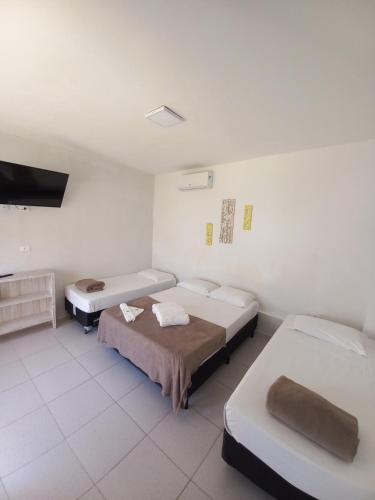um quarto com 2 camas e uma televisão de ecrã plano em Hotel e Pousada Pouso54 em Ubatuba