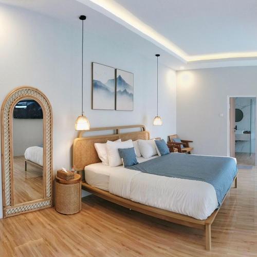 a bedroom with a large bed and a mirror at San Villa Syariah in Banjarbaru