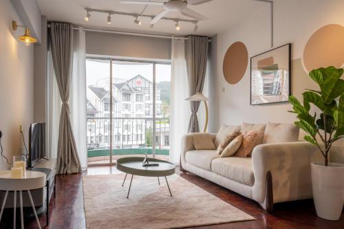 a living room with a couch and a large window at Star Regency by Plush in Brinchang