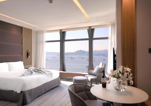 a hotel room with a bed and a large window at Oasis Aurum 181 Hotel in Hong Kong