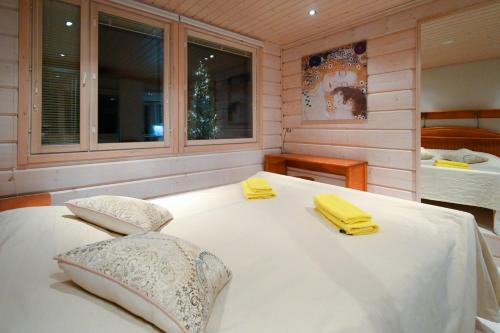 a bedroom with a large white bed with yellow towels on it at PielisLinna in Kolinkylä
