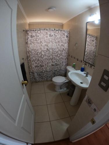 een badkamer met een wastafel, een toilet en een douche bij My Home in La Serena