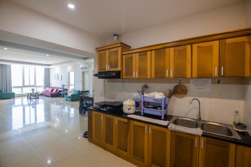 a kitchen with wooden cabinets and a counter top at Sơn Thịnh - Oasky Apartment in Vung Tau