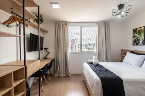 1 dormitorio con cama, escritorio y ventana en MV14 - Studio Próximo à Estação Brás: Conforto Garantido, en São Paulo