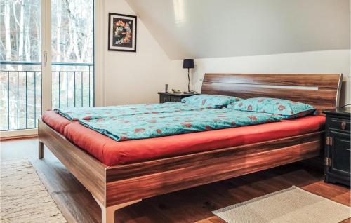 1 dormitorio con 1 cama grande de madera con colchón rojo en Cozy Home In Feldbach With Kitchen, en Feldbach