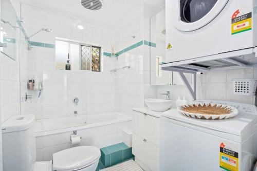 bagno bianco con servizi igienici e lavandino di Alfred Street - Hosted by Burleigh Letting a Gold Coast