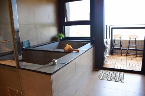 a bathroom with a tub with a table and chairs at 海上玩家 景觀溫泉小館 in Toucheng