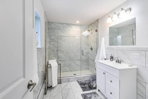 a white bathroom with a shower and a sink at Oakton St Inn Evanston Northwestern Chicago Loyola in Evanston