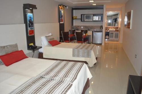 a hotel room with two beds and a kitchen at Sol de Piedra Apart, Suites & Spa in Cordoba