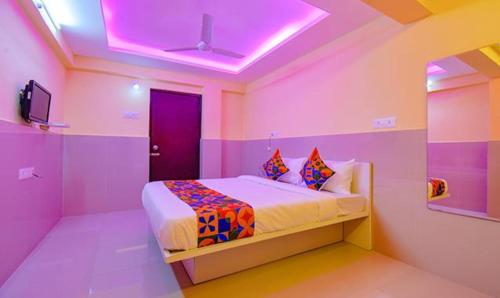 1 dormitorio con paredes rosas y moradas y 1 cama en FabHotel Empire Executive, en Pune
