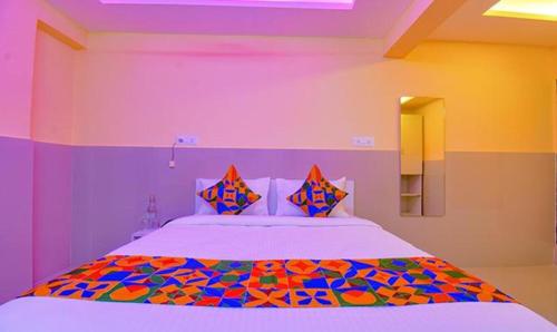 ein Schlafzimmer mit einem großen Bett mit bunten Kissen in der Unterkunft FabHotel Empire Executive in Pune