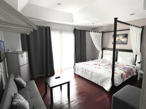 a bedroom with a bed and a living room with a couch at Thalassa Kata Beach in Kata Beach