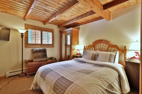 een slaapkamer met een groot bed en een stoel bij Tanglewood Chalet- 4 BR 4 BA Family Home in Killington, Perfect for Groups home in Killington