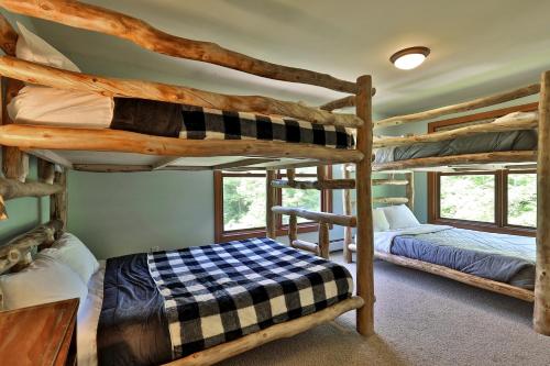 a bedroom with two bunk beds in a cabin at Cortina Mountain Chalet - Outdoor Hot Tub - Close to Pico and Killington Mountains home in Mendon