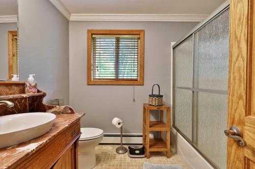 a bathroom with a sink and a glass shower at Tanglewood Chalet- 4 BR 4 BA Family Home in Killington, Perfect for Groups home in Killington