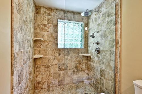 een badkamer met een douche en een stenen muur bij Tanglewood Chalet- 4 BR 4 BA Family Home in Killington, Perfect for Groups home in Killington
