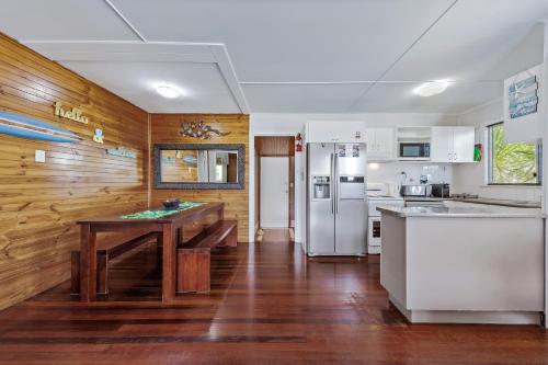 a kitchen with a table and a refrigerator at Airlie Getaway - Airlie Beach in Airlie Beach