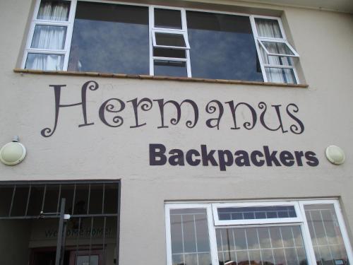 a building with a sign on the front of it at Hermanus Backpackers & Budget Accommodation in Hermanus