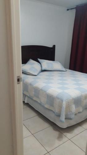 a bedroom with a bed with a blue and white comforter at Departamento 5 minutos Playa cavancha in Iquique