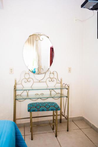 a mirror and a chair in a room at Bungalows Maria Teresa in Rincon de Guayabitos