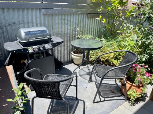 a patio with a table and two chairs and a grill at Cloudscape Apartment No 2 in Kingscote