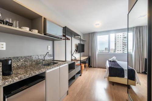 una cocina con fregadero y una cama en una habitación en MV136B - Encanto nas Proximidades da Estação Brás: Seu Estúdio Acolhedor!, en São Paulo