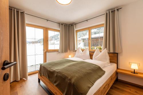 1 dormitorio con 1 cama grande y 2 ventanas en Tiroli en Westendorf