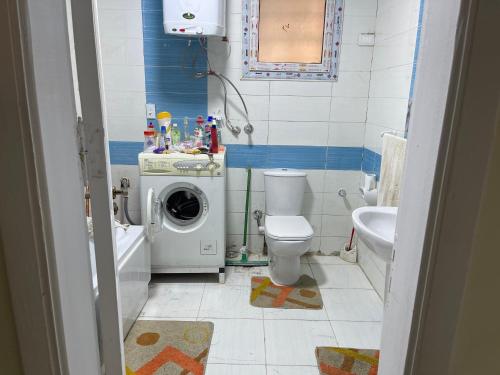 une salle de bain avec une machine à laver et un lave-linge dans l'établissement Gardenia city cairo, au Caire