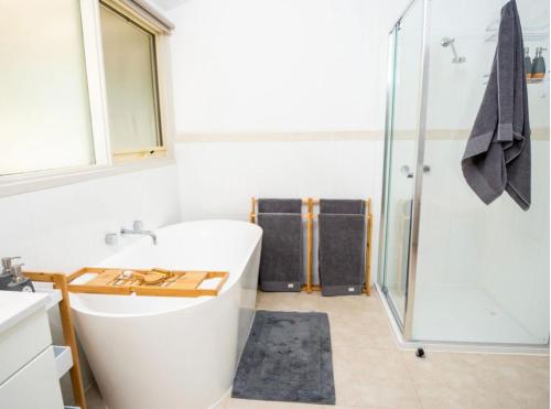 a bathroom with a white tub and a shower at Don Valley Lodge in Launching Place