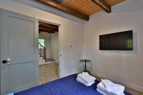 a bedroom with a bed with a tv on the wall at Left Duplex Home Directly Across From Pico Mountain, Close to Killington, home in Killington
