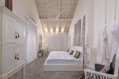 a white bedroom with a bed and a ceiling at W15 Escape in Ahangama