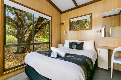 een slaapkamer met een bed en een groot raam bij BIG4 Breeze Holiday Parks - Port Elliot in Port Elliot