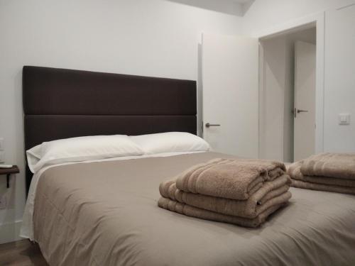1 dormitorio con 1 cama con 2 toallas en El PORTON DE LA BELLOTA - CON PARKING GRATIS - EN EL CENTRO DE TOLEDO, en Toledo