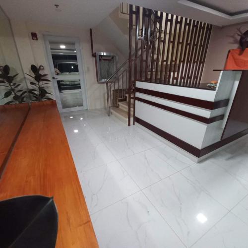 a living room with a staircase and white tile floors at Visita highland Inn in Baguio