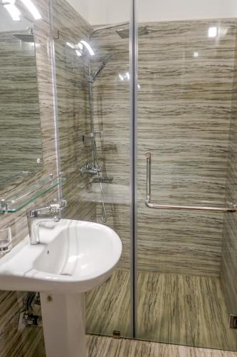a bathroom with a sink and a shower at Vista Apartment Mariners Blue in Nuwara Eliya