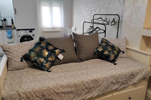 una cama con varias almohadas en una habitación en Logroño Centro Home, en Logroño