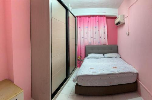 a small bedroom with a bed in a pink room at Penthouse 4 Bedroom Seaview in Port Dickson
